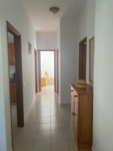 Habitación con pasillo con paredes blancas y habitación con mesa. en House at Santiago del Teide, en Tamaimo