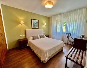 1 dormitorio con cama, mesa y ventana en Hotel La Rivera, en Arenas de Cabrales