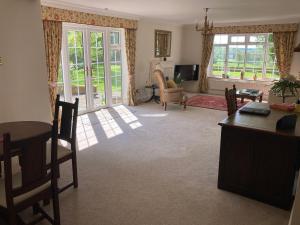 a living room with a desk and a table and chairs at Exclusive Two Bedroom Apartment with Summer House and Hot Tub in Daventry