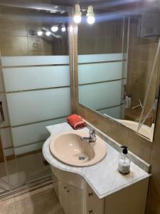 een badkamer met een wastafel en een spiegel bij Room Valdeolleros in Córdoba