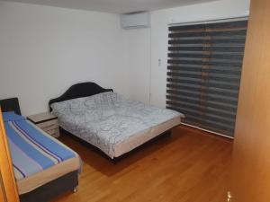 een kleine slaapkamer met een bed en een raam bij AK apartments in Kamenjača