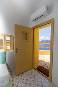 a room with a door with a view of the beach at Villa Ariadni Cave Houses in Oia in Oia