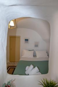 1 dormitorio con 1 cama con 2 toallas en Villa Ariadni Cave Houses in Oia, en Oia