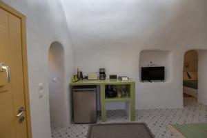 Habitación con mesa pequeña y TV. en Villa Ariadni Cave Houses in Oia, en Oia
