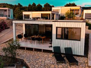 a house with a patio with a table and chairs at MODERN BEACH VILLAS - Buqez Camp resort in Drage