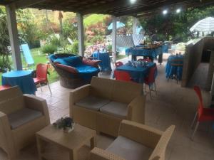 a patio with couches and tables and chairs at Pousada Recanto dos Arcos in Conservatória
