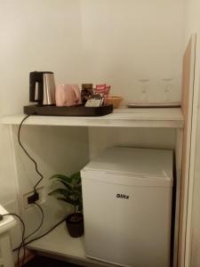 a white shelf with a trash can under a table at Rooms Serafin in Motovun +15 photos