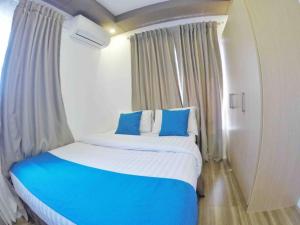 a bedroom with a large bed with blue pillows at Stylish Townhouse in Balanga City Quiet Neighborhood in Balanga