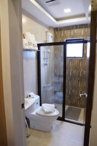 a bathroom with a toilet and a glass shower at Stylish Townhouse in Balanga City Quiet Neighborhood in Balanga