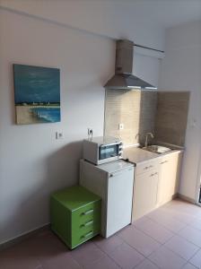 a small kitchen with a sink and a microwave at Halkidiki Rooms in Nea Fokea