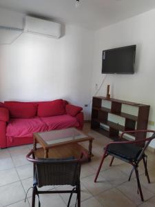 a living room with a red couch and a table and chairs at Las chismosas in Santiago del Estero