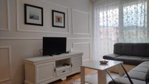 a living room with a flat screen tv on a cabinet at Apartment Allure in Čapljina