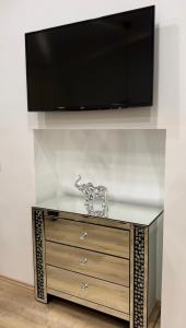 a dresser with a flat screen tv on a wall at City Apartment Chiara in Maribor