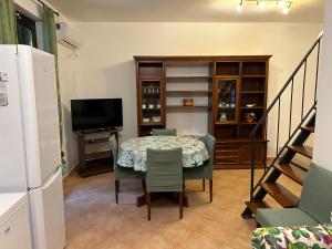 a dining room with a table and chairs and a television at Villetta sul mare in Resort Village in Campofelice di Roccella