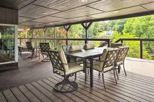 una terraza de madera con mesa y sillas. en Modern Lakefront Home with Dock, Deck and Boat Slip!, en Eucha