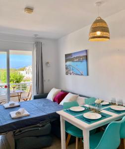 a living room with a table and a couch at Apartament Sa Farola - AC, WiFi , Pool, Beach in Cala en Blanes