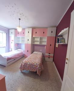 a bedroom with two beds and pink and white cabinets at Relax vicino Ascoli Piceno in Ascoli Piceno