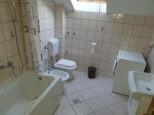 een badkamer met een toilet, een bad en een wastafel bij AK apartments in Kamenjača