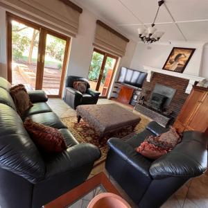 a living room with leather furniture and a fireplace at Peaceful@Swansea In Rosebank-Parkwood in Johannesburg