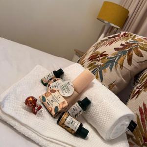 uma pilha de toalhas e um rolo de papel higiénico numa cama em Peaceful@Swansea In Rosebank-Parkwood em Joanesburgo
