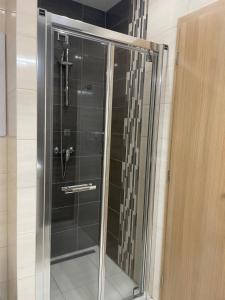 una ducha en un baño con puerta de cristal en Apartment Pinia, en Starý Smokovec 5 fotos más