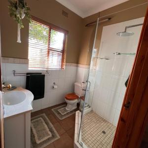 uma casa de banho com um chuveiro, um WC e um lavatório. em Peaceful@Swansea In Rosebank-Parkwood em Joanesburgo