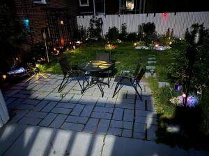 a patio with a table and chairs in a yard at night at F.M.T. in Harrisburg