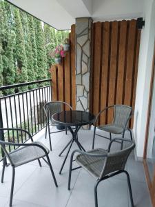 a patio with three chairs and a table on a balcony at ZYCH - Domek in Chochołów
