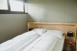 twee bedden in een kamer met twee ramen bij Boshuisje Rekem - Rivus in Lanaken