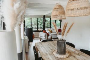 salon z drewnianym stołem i krzesłami w obiekcie Boshuisje Rekem - Rivus w mieście Lanaken