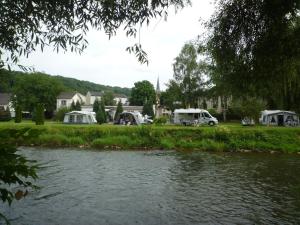 a river with two rvs parked next to a field at Minitent Reisdorf in Reisdorf