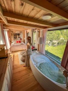 a woman standing in a bath tub in a bedroom at Vagona Tiny House in Rize