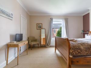 Dormitorio con cama, escritorio y TV en Cosy 2 bedroom house in the heart of Morpeth en Morpeth