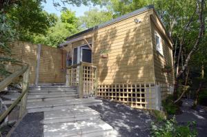 una casa pequeña con escaleras que conducen a la puerta en Tawny Lodge en Westport