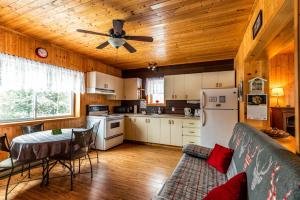 a kitchen with a couch and a ceiling fan at Domaine de La Giroux-ette in La Patrie