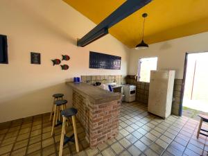 a kitchen with a brick counter and stools in it at Casa Saberé - 100m da Praia - 2 Suítes - 4 adultos in Porto De Galinhas