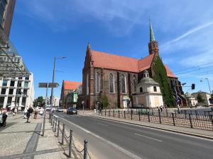 eine Kirche mit einem Kirchturm auf der Straßenseite in der Unterkunft I&M Apartments Krawiecka Wrocław in Breslau