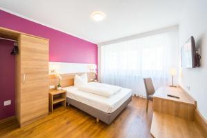 1 dormitorio con cama blanca y pared morada en Hotel S16 en Múnich