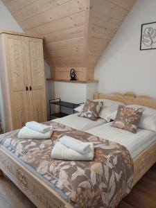 a bedroom with a large bed with pillows on it at Pokoje Gościnne ZYCH - Domek in Chochołów