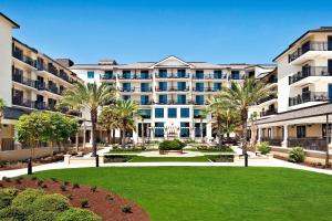 a large apartment building with a lawn and palm trees at The Westin Jekyll Island in Jekyll Island