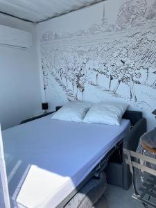 Bett in einem Zimmer mit Wandgemälde in der Unterkunft Conteneur face aux vignes in Massillargues-Attuech
