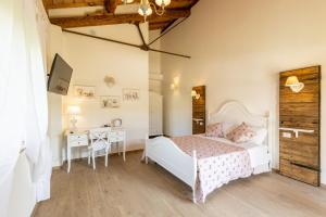 a bedroom with a white bed and a desk at B&B Podere Curtatone in Grosseto