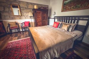 a bedroom with a large bed and a red rug at Padláskincsek Vendégház in Nagybörzsöny +62 photos
