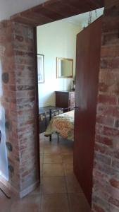 Zimmer mit Ziegelwand und Schlafzimmer in der Unterkunft Casa Patti alle porte di Siena in Siena