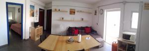 Elle comprend un petit salon avec une table et une télévision. dans l'établissement Flat near cathedral. 3 bedrooms., à Cadix