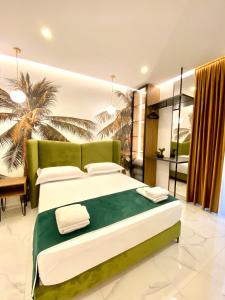 a bedroom with a large bed and a palm tree at Apartments Oda Hotel in Velipojë +291 photos