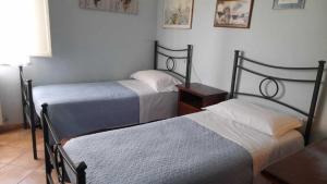 ein Schlafzimmer mit 2 Betten und einem Tisch mit einer Lampe in der Unterkunft Casa Patti alle porte di Siena in Siena