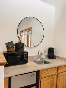 encimera de cocina con microondas y espejo en Cozy Cabin suite bed and breakfast en Woodland Park