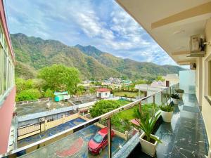a balcony with a view of a city and mountains at Tapovan New Residency - 5 minutes walk to Laxman jhula in Rishīkesh