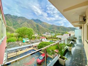 a balcony with a view of a city and mountains at Tapovan New Residency By FTP Hotels in Rishīkesh